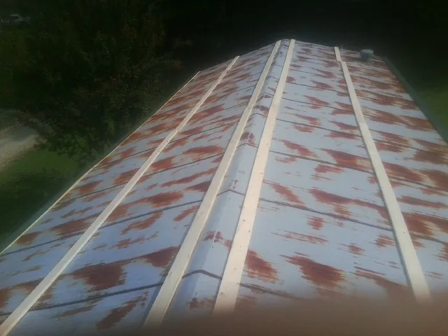 Rusted metal roof panels with new wood purlins before replacement — Storm Damage Roof Repair in Peachtree Corners by Roofing Brothers
