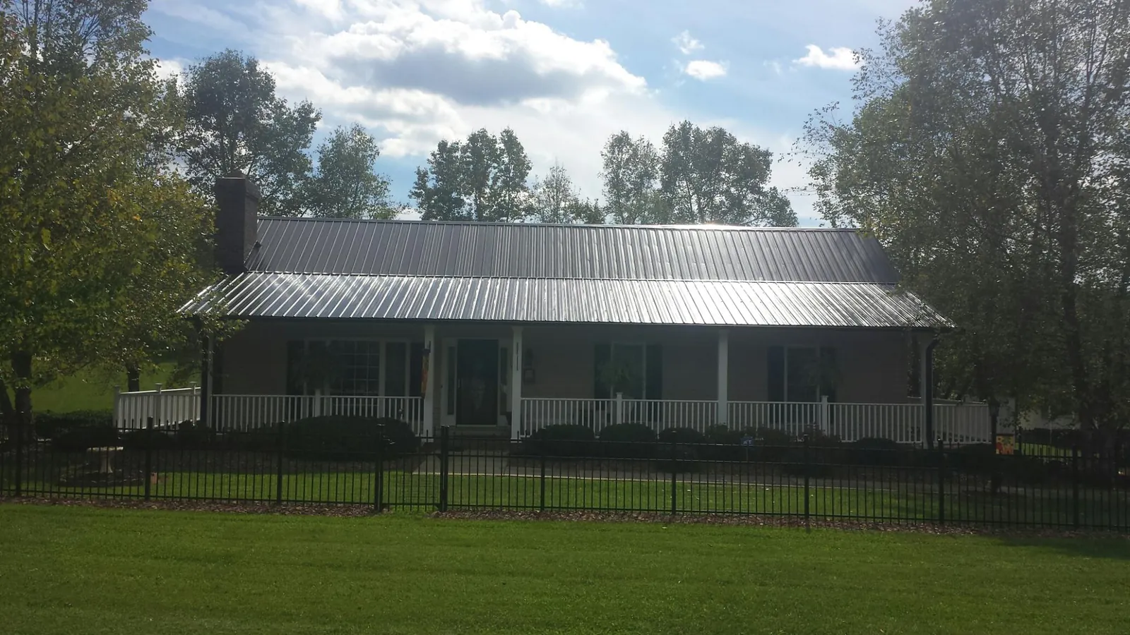 Gray metal roof on a brick ranch with a full width front porch — Gutter Guard Installation work by our crew in Peachtree Corners