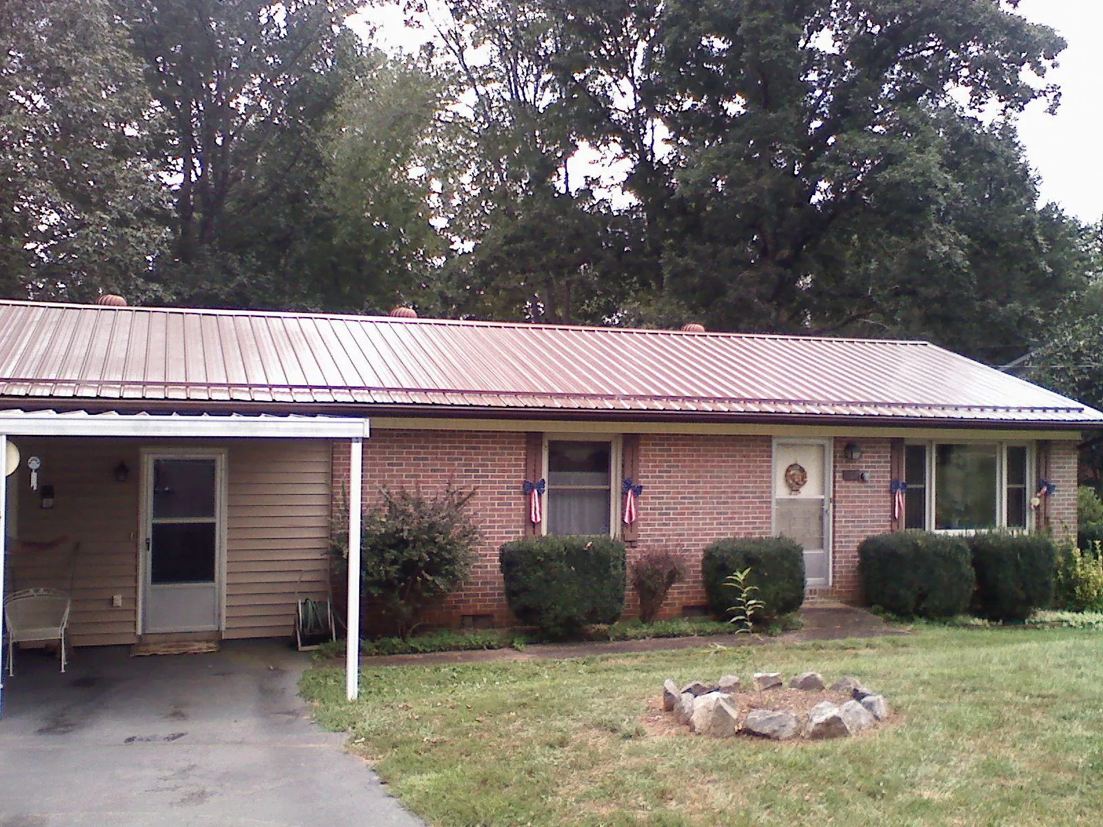 Bronze metal roof and carport on a brick ranch home — Roof Repair work by our crew in Peachtree Corners