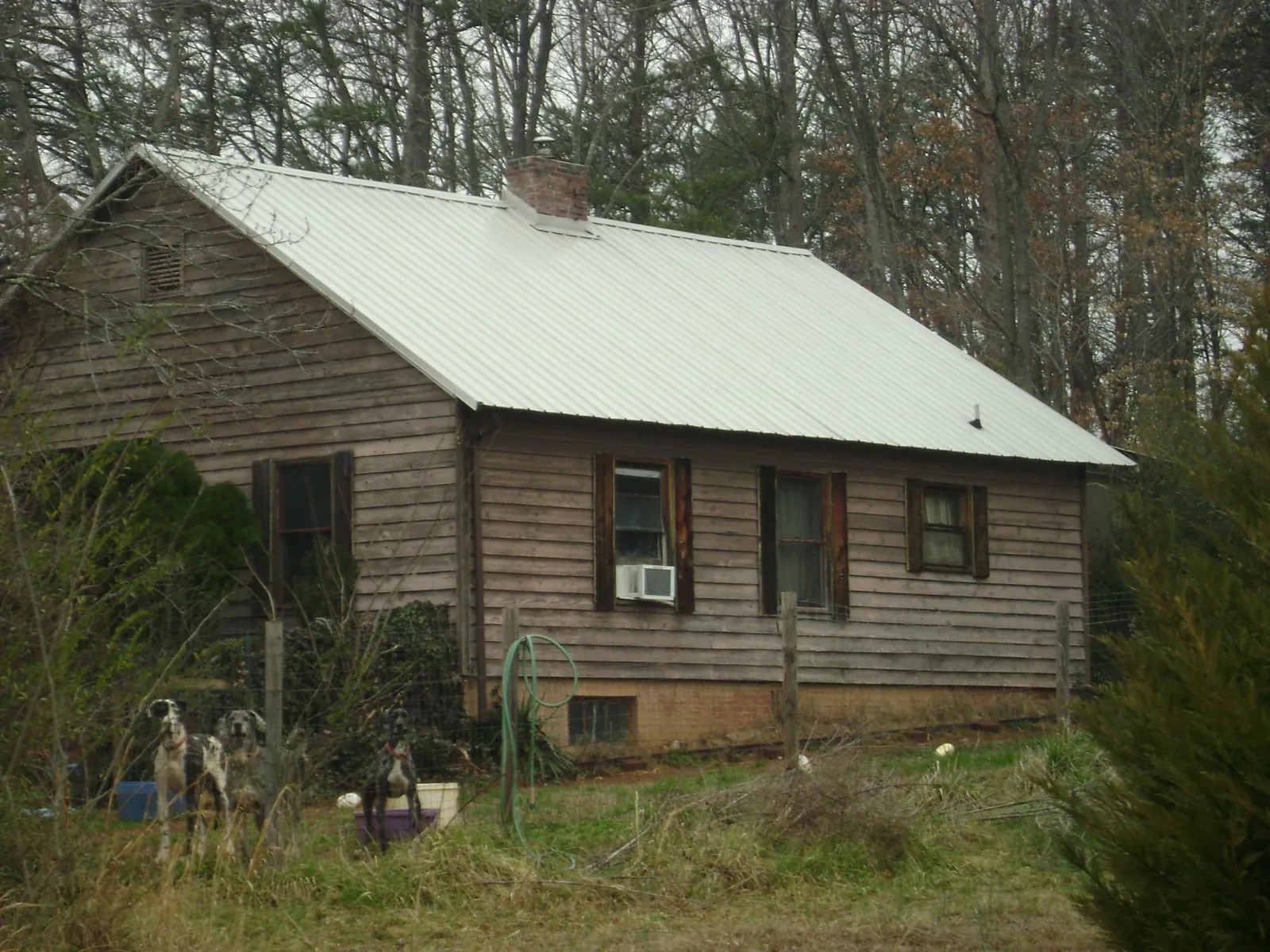 White metal roof on an old wood sided farmhouse, from a Metal Roof Installation job in Peachtree Corners